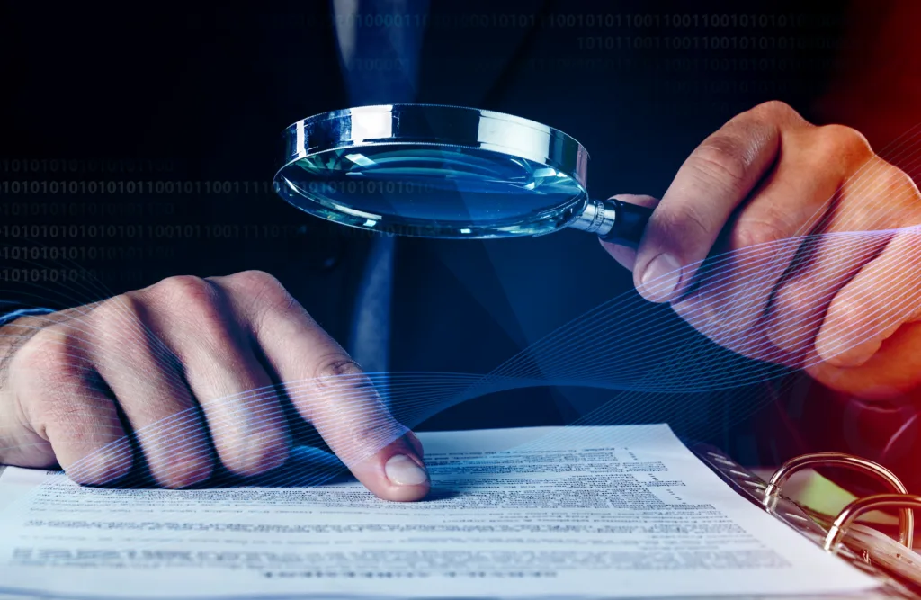 auditor doing tax fraud investigation using magnifying glass papers